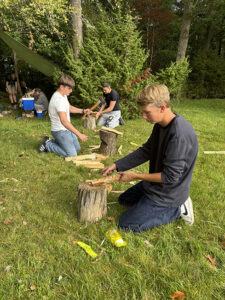 Elever på Tänk H2O! hugger vid vid en lägerplats utomhus.