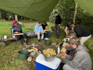 Elever på Tänk H2O! förbereder middagen som vid en lägerplats utomhus.