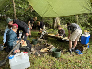 Elever på Tänk H2O! förbereder middagen som vid en lägerplats utomhus.