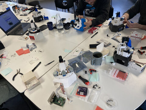 Ett bord med mikroskop och delar till mikroskop.