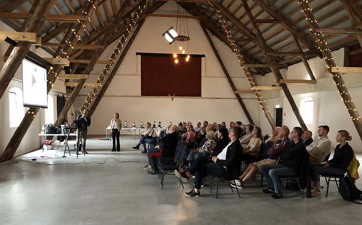 Temadag Vombsjön blommar. publik och presentatör i stora hallen på Övedskloster